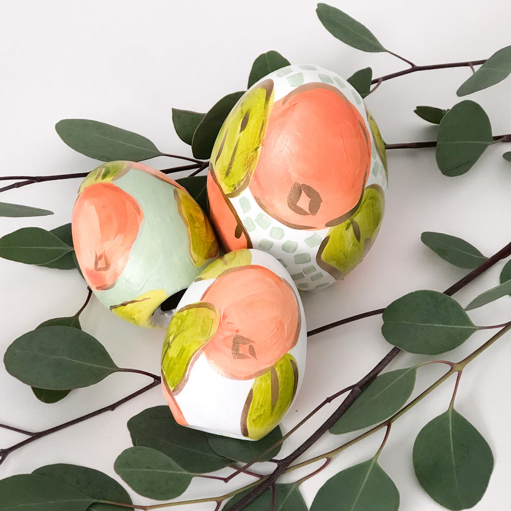 Hand painted ceramic easter eggs featuring oranges.