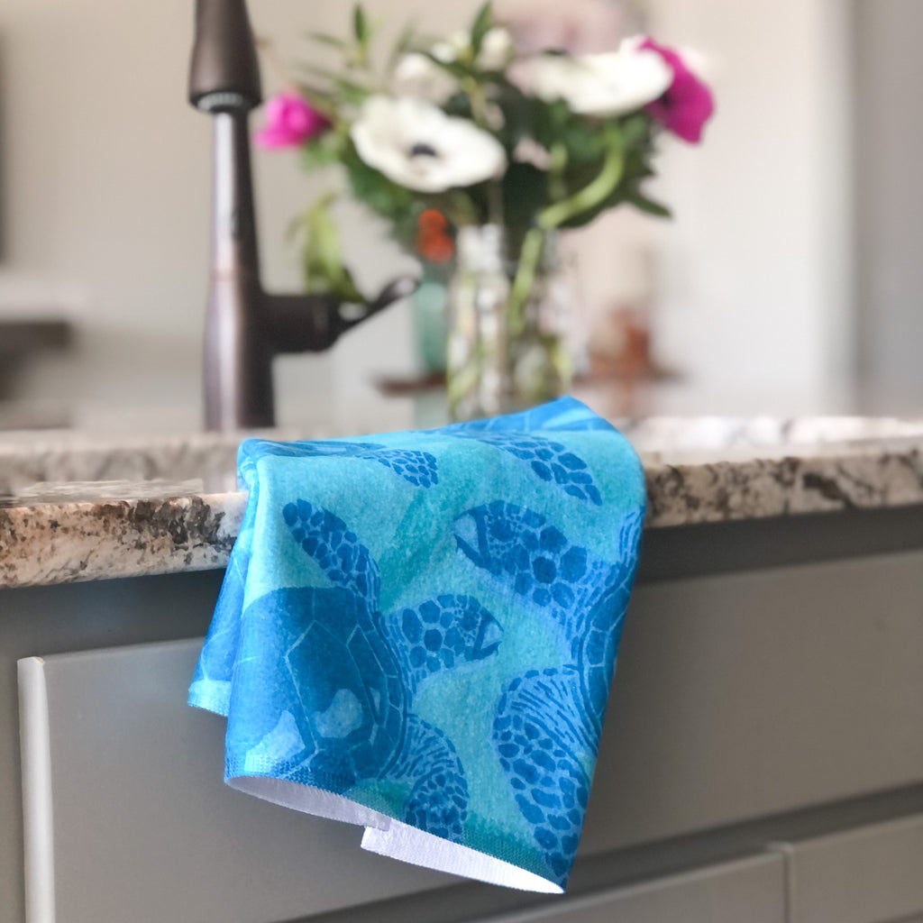 Tea towel hand designed by Jessica Reynolds art. Featuring sea turtles on a microfiber towel with a terri loop backing.